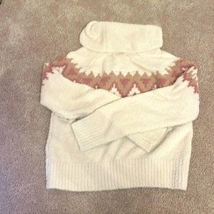 selling a fluffy turtle neck sweater that is cream with Neutral coloured designs